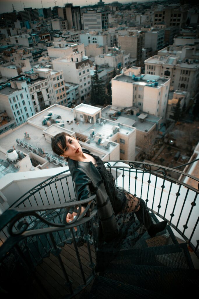 black dress and jacket on staircase-city in background